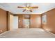 Bedroom featuring carpet, a ceiling fan, and a window, with views into an attached bathroom and hallway at 6944 S Morning Dew Ln, Buckeye, AZ 85326