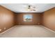 Spacious bedroom with neutral carpet, a ceiling fan, and a window providing ample natural light at 6944 S Morning Dew Ln, Buckeye, AZ 85326