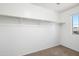 An empty closet space with white walls, shelving, and a window, ready for storage at 6944 S Morning Dew Ln, Buckeye, AZ 85326