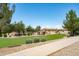 View of community park featuring lush green grass, playground, picnic tables and mature trees at 6944 S Morning Dew Ln, Buckeye, AZ 85326