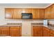 Close up on wood cabinets with countertop space and appliances in a well-lit kitchen area at 6944 S Morning Dew Ln, Buckeye, AZ 85326