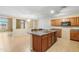 Spacious open floor plan with a kitchen island, cabinetry, tile floors, and adjoining dining space at 6944 S Morning Dew Ln, Buckeye, AZ 85326