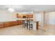 Open kitchen features a center island with bar seating, ample cabinets, and tile floors at 6944 S Morning Dew Ln, Buckeye, AZ 85326