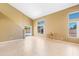 Bright living room boasts tile flooring, high ceilings, and natural light from large windows and sliding glass doors at 6944 S Morning Dew Ln, Buckeye, AZ 85326