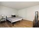 Comfortable bedroom with hardwood floors, side tables, a dresser and a bed with a gray comforter at 7625 E Camelback Rd # B226, Scottsdale, AZ 85251