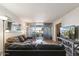 Open living room with an entertainment center, plush gray sofas, an access to the patio, and a view to the bedroom at 7625 E Camelback Rd # B226, Scottsdale, AZ 85251