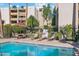 Community pool with lounge chairs and tables, surrounded by mature landscaping and inviting atmosphere at 7625 E Camelback Rd # B226, Scottsdale, AZ 85251