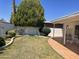 View of a backyard featuring a well-maintained lawn, a tile-covered patio, and mature trees, providing a serene outdoor space at 7637 E Thornwood Dr, Scottsdale, AZ 85251