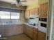 Functional kitchen with ample cabinet space, vintage appliances, and a bright window at 7637 E Thornwood Dr, Scottsdale, AZ 85251