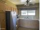 Well-lit kitchen with stainless steel refrigerator, window over sink, and plenty of storage at 7637 E Thornwood Dr, Scottsdale, AZ 85251