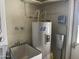 Utility room featuring a water heater and a utility sink at 7637 E Thornwood Dr, Scottsdale, AZ 85251