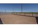 An open dirt backyard enclosed with a wall and metal fencing, with neighborhood views beyond at 7956 W Griswold Rd, Peoria, AZ 85345