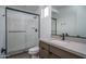 Well-lit bathroom featuring a tiled shower with glass door, a toilet, and a sleek vanity with neutral countertop at 7956 W Griswold Rd, Peoria, AZ 85345
