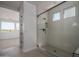 Modern bathroom showcasing glass-enclosed shower with black trim and tiled walls plus a glimpse of the bedroom at 7956 W Griswold Rd, Peoria, AZ 85345