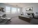 Bright bedroom with a large window, neutral color scheme, and a comfy chair and ottoman at 7956 W Griswold Rd, Peoria, AZ 85345