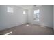 Bright bedroom with carpet, white walls and trim, and two windows at 7956 W Griswold Rd, Peoria, AZ 85345
