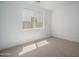 Well-lit bedroom with carpet, white walls, a large window, and electrical outlets at 7956 W Griswold Rd, Peoria, AZ 85345