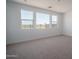 Well-lit bedroom with plush carpeting and large windows offering bright, natural light at 7956 W Griswold Rd, Peoria, AZ 85345