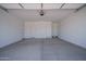 A spacious garage with painted walls, two entry doors and painted concrete flooring at 7956 W Griswold Rd, Peoria, AZ 85345