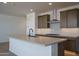 A spacious kitchen features an island with a sink and bar seating, modern appliances, and ample counter space at 7956 W Griswold Rd, Peoria, AZ 85345