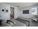 A neutral bedroom with modern furnishings including a platform bed, mounted TV and a view of the bath at 7956 W Griswold Rd, Peoria, AZ 85345
