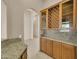 A wet bar with custom cabinets, granite counters and a wine rack at 8031 W Morten Ave, Glendale, AZ 85303