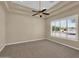 Neutral bedroom featuring plush carpeting, tray ceilings, a ceiling fan, and plantation shutters at 8031 W Morten Ave, Glendale, AZ 85303