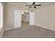 Comfortable bedroom featuring plush carpets, a ceiling fan, and double doors leading to another room at 8031 W Morten Ave, Glendale, AZ 85303