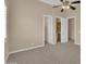 Large carpeted bedroom features a ceiling fan, a window and ensuite bathrooms at 8031 W Morten Ave, Glendale, AZ 85303