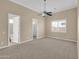 Large carpeted bedroom features a ceiling fan, a window and ensuite bathrooms at 8031 W Morten Ave, Glendale, AZ 85303