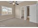 Carpeted bedroom features a ceiling fan, walk-in closet and an ensuite bathroom at 8031 W Morten Ave, Glendale, AZ 85303