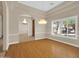 Open-concept dining room with hardwood floors, decorative moldings, and a large window at 8031 W Morten Ave, Glendale, AZ 85303