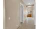 Neutral hallway with tiled floors leads to the arched entrance of the bright, modern bathroom with ample counter space at 8031 W Morten Ave, Glendale, AZ 85303