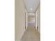 Neutral hallway with tiled floors leads to a bedroom with carpet and a ceiling fan above at 8031 W Morten Ave, Glendale, AZ 85303