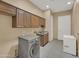 Functional laundry room with modern washer, dryer, and ample storage at 8031 W Morten Ave, Glendale, AZ 85303