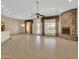 Spacious living room featuring tile flooring, a stone fireplace, and a view of the pool area at 8031 W Morten Ave, Glendale, AZ 85303