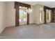 The empty living room features decorative window coverings overlooking the pool and tile floors at 8031 W Morten Ave, Glendale, AZ 85303