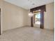 An empty living room features tan walls, tile floor, and decorative window covering at 8031 W Morten Ave, Glendale, AZ 85303