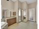 Spacious Primary bathroom featuring tiled floors, granite countertop vanities, soaking tub, and glass-enclosed shower at 8031 W Morten Ave, Glendale, AZ 85303