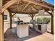 Covered outdoor kitchen with ample counter space and grill, ideal for hosting outdoor gatherings at 8031 W Morten Ave, Glendale, AZ 85303