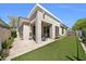 Back exterior featuring a covered patio, neutral stucco finish, and a manicured backyard at 8180 E Shea Blvd # 1019, Scottsdale, AZ 85260