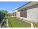 Backyard showcasing green artificial turf, a neutral-colored stucco wall, and trimmed greenery at 8180 E Shea Blvd # 1019, Scottsdale, AZ 85260