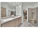 Bathroom featuring double sinks, sleek countertops, and a glass shower with a wooden bench at 8180 E Shea Blvd # 1019, Scottsdale, AZ 85260