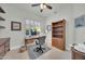 Bright home office featuring a ceiling fan, wood desk, wooden bookcase, and natural light from a window at 8180 E Shea Blvd # 1019, Scottsdale, AZ 85260
