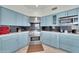 Kitchen featuring light blue cabinetry, stainless steel appliances, and a sleek black backsplash at 8180 E Shea Blvd # 1019, Scottsdale, AZ 85260