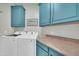 Bright laundry room with blue cabinets and modern appliances at 8180 E Shea Blvd # 1019, Scottsdale, AZ 85260