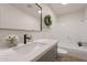 Bright bathroom featuring a modern vanity, stylish mirror, and a shower-tub combination with a gray cabinet at 909 S Acapulco Ln # A, Tempe, AZ 85281