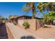 Exterior view of a house surrounded by mature trees and shrubs, complemented by a concrete block wall at 909 S Acapulco Ln # A, Tempe, AZ 85281