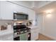 A modern kitchen with stainless steel appliances, white cabinets and marble-style countertops at 909 S Acapulco Ln # A, Tempe, AZ 85281