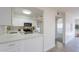 Open kitchen layout with modern appliances, white cabinets, marble-style countertops and light wood flooring at 909 S Acapulco Ln # A, Tempe, AZ 85281